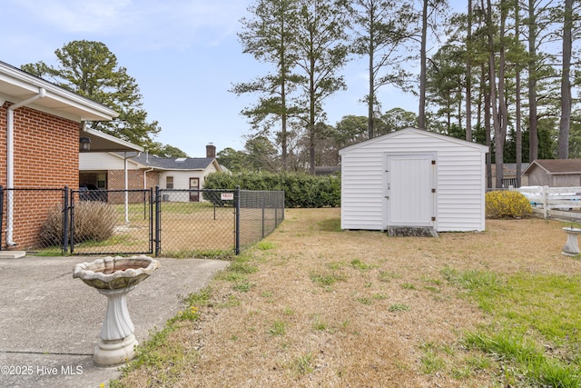 view of yard with an outbuilding, a gate, fence, and a shed