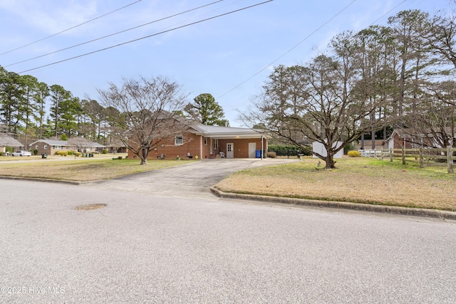 view of front of house featuring fence, a front lawn, and aphalt driveway