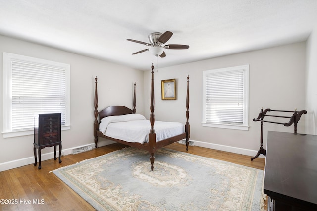 bedroom with light wood-type flooring, visible vents, baseboards, and ceiling fan