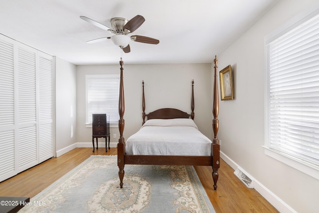 bedroom featuring visible vents, multiple windows, light wood-style flooring, and baseboards