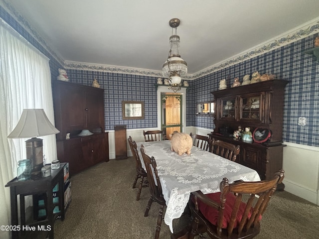 dining room featuring carpet flooring, a notable chandelier, baseboards, and wallpapered walls