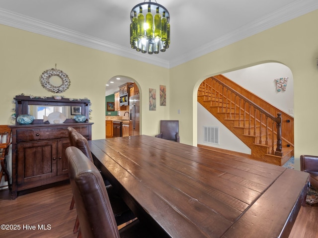 dining space featuring visible vents, stairs, an inviting chandelier, arched walkways, and dark wood-style flooring