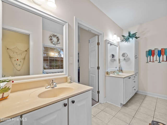 bathroom featuring tile patterned floors, two vanities, and a sink