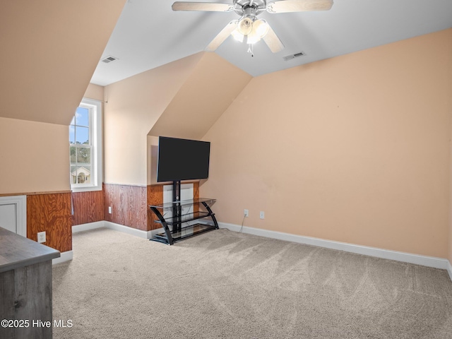 interior space featuring lofted ceiling, carpet flooring, visible vents, and ceiling fan