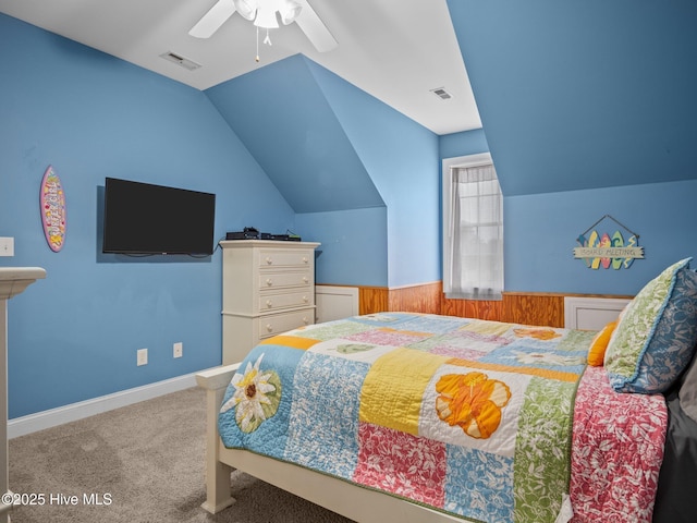 carpeted bedroom with visible vents, lofted ceiling, a ceiling fan, and wainscoting