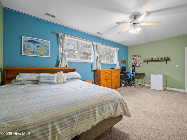 carpeted bedroom featuring visible vents, ceiling fan, refrigerator, and baseboards