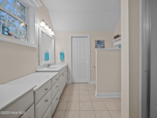 full bath featuring baseboards, lofted ceiling, vanity, and tile patterned flooring