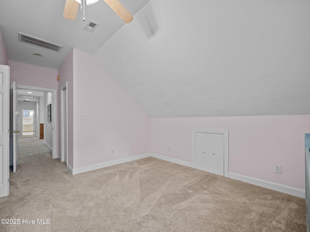 bonus room with visible vents, lofted ceiling, and light colored carpet