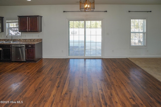 interior space featuring dark wood-type flooring, plenty of natural light, a sink, and baseboards