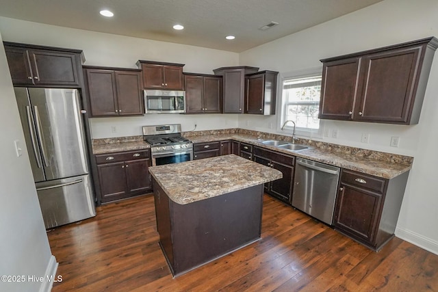 kitchen with dark wood-style flooring, visible vents, appliances with stainless steel finishes, a sink, and dark brown cabinets