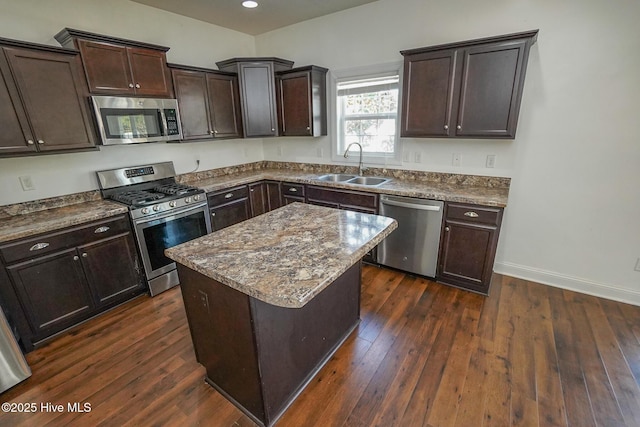 kitchen featuring dark brown cabinets, appliances with stainless steel finishes, dark wood-style flooring, and a sink