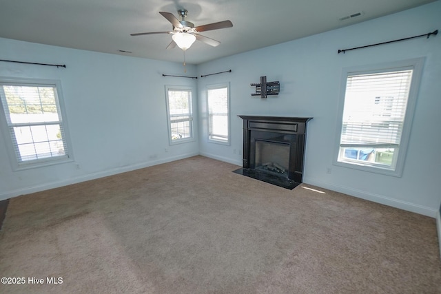 unfurnished living room featuring a fireplace with flush hearth, visible vents, carpet floors, and baseboards