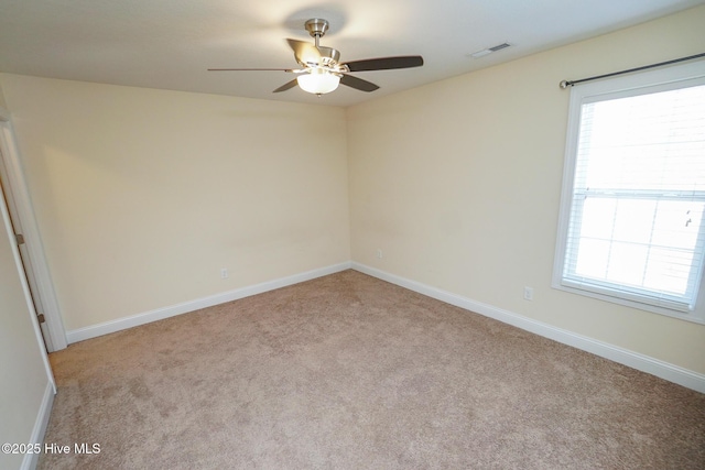 spare room with carpet, baseboards, and visible vents