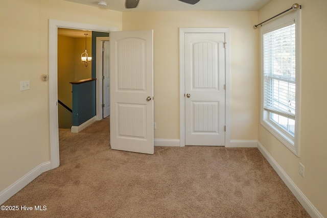 unfurnished bedroom featuring carpet flooring, baseboards, and multiple windows