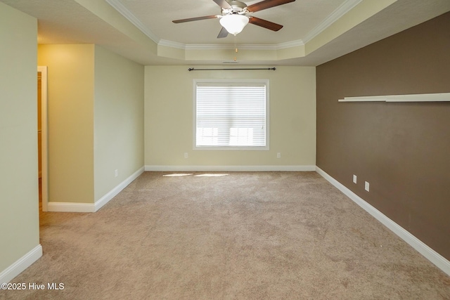 unfurnished room featuring baseboards, a raised ceiling, and crown molding