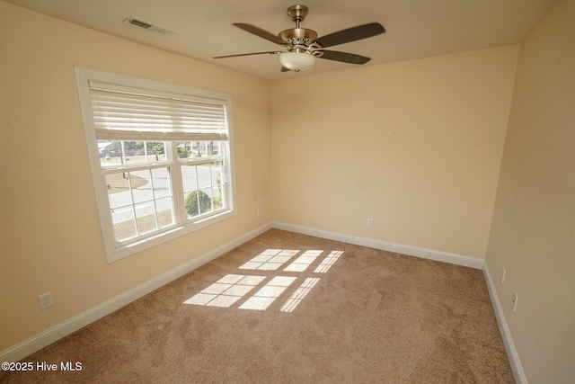 spare room featuring a ceiling fan, carpet, visible vents, and baseboards