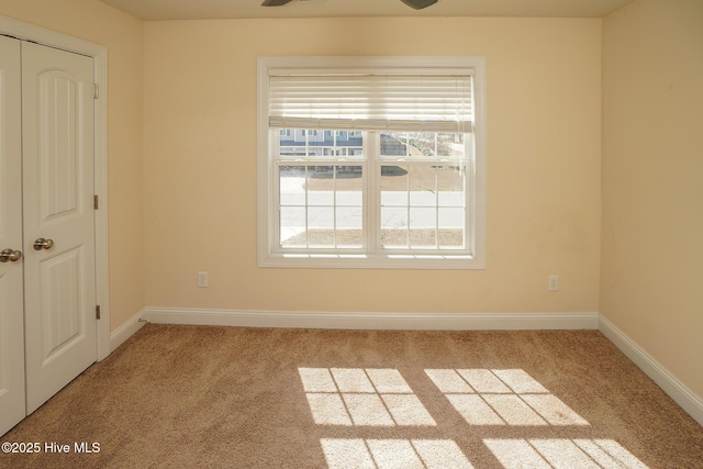 spare room featuring carpet floors and baseboards