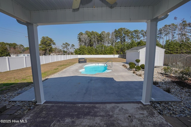 view of swimming pool with a patio, a lawn, a shed, a fenced backyard, and an outdoor structure