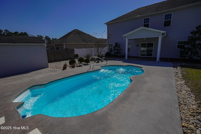 view of swimming pool featuring a patio, an outdoor structure, fence, and a fenced in pool