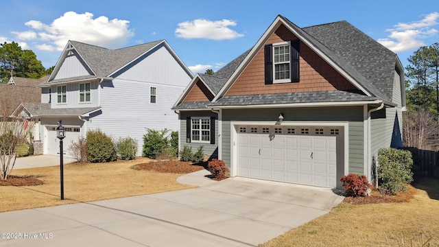 view of front of house featuring a shingled roof, driveway, and an attached garage