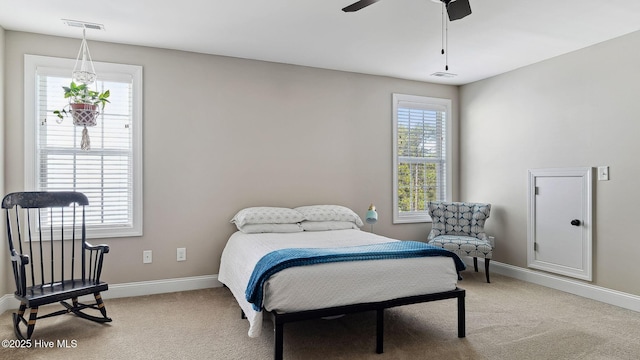 bedroom with baseboards, visible vents, a ceiling fan, and light colored carpet