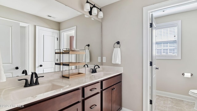 full bath featuring baseboards, a sink, toilet, and double vanity