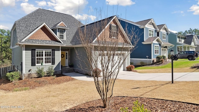 view of front facade featuring a garage, concrete driveway, roof with shingles, and a residential view