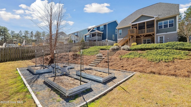 view of yard with a residential view, a garden, fence, and stairs