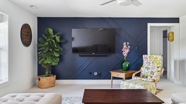 living area featuring a ceiling fan, carpet, visible vents, and baseboards