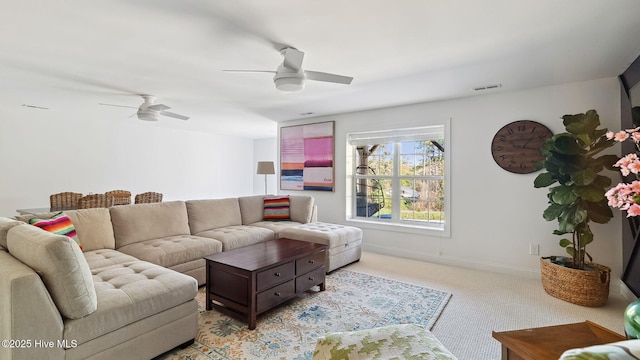 living room featuring light carpet, ceiling fan, visible vents, and baseboards