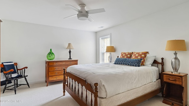 bedroom featuring a ceiling fan, light colored carpet, visible vents, and baseboards