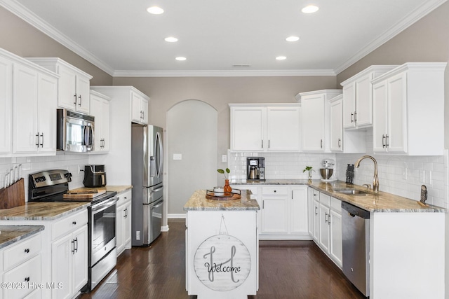 kitchen featuring a sink, appliances with stainless steel finishes, dark wood finished floors, and white cabinets