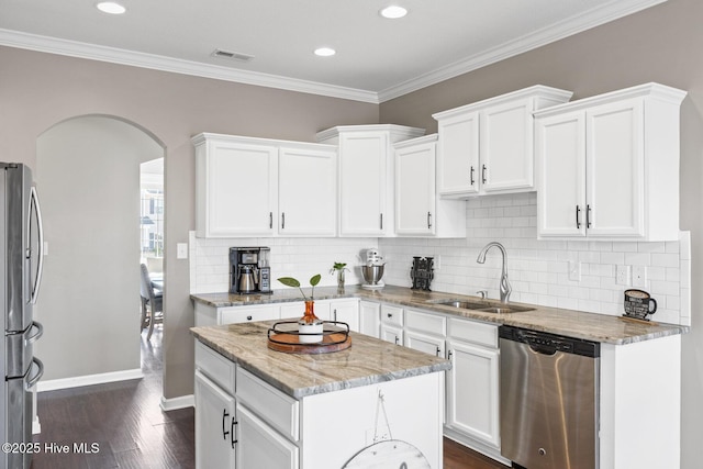 kitchen with visible vents, arched walkways, white cabinets, stainless steel appliances, and a sink