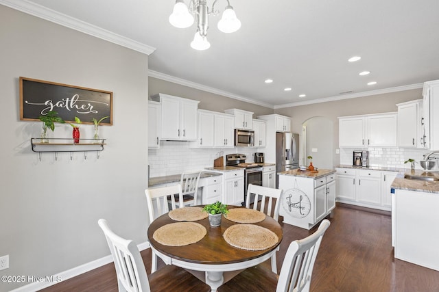 dining room with baseboards, dark wood-type flooring, an inviting chandelier, and crown molding