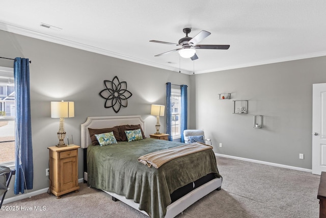 bedroom with a ceiling fan, baseboards, visible vents, ornamental molding, and light carpet