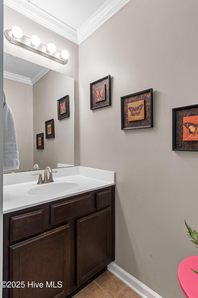 bathroom with tile patterned floors, vanity, baseboards, and ornamental molding