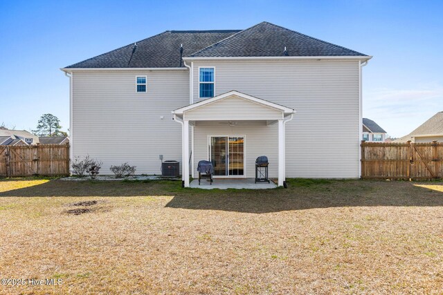 back of house with a patio area, central air condition unit, a lawn, and fence