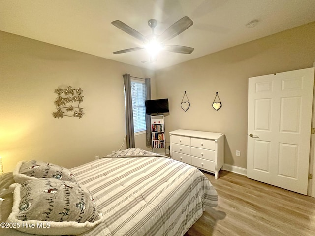 bedroom with a ceiling fan, baseboards, and wood finished floors