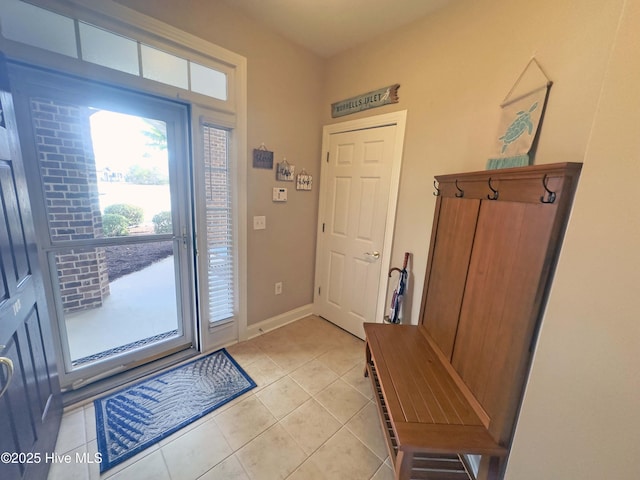 foyer featuring light tile patterned flooring and baseboards