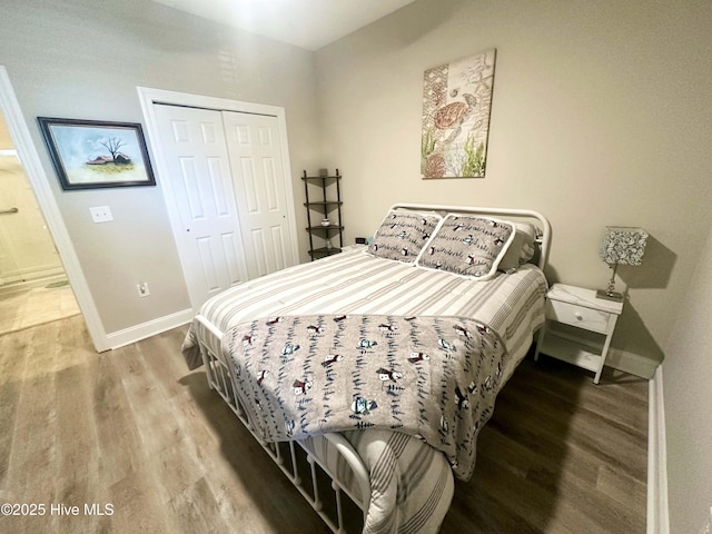 bedroom with a closet, baseboards, and wood finished floors