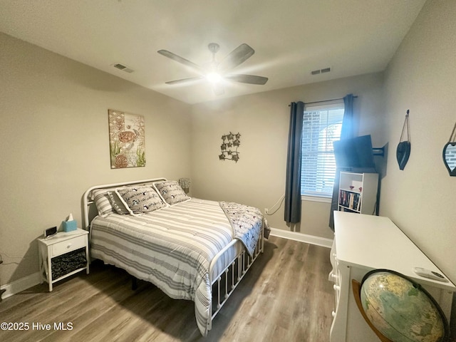 bedroom with wood finished floors, visible vents, and baseboards