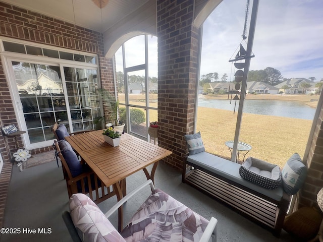 sunroom / solarium with arched walkways and a water view