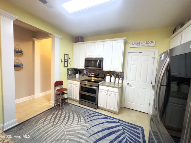 kitchen with ornate columns, white cabinetry, and appliances with stainless steel finishes