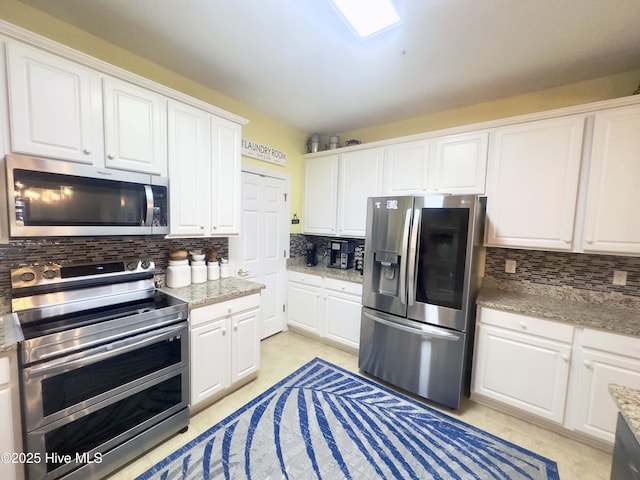 kitchen featuring stainless steel appliances, white cabinetry, and decorative backsplash