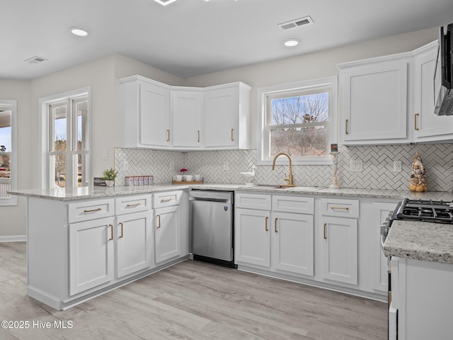 kitchen featuring a sink, visible vents, white cabinetry, appliances with stainless steel finishes, and light wood finished floors