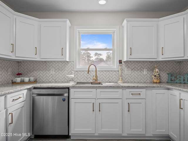 kitchen with dishwasher, tasteful backsplash, a sink, and white cabinets