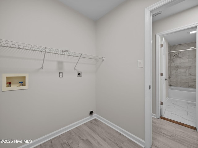 clothes washing area with laundry area, visible vents, baseboards, hookup for a washing machine, and hookup for an electric dryer