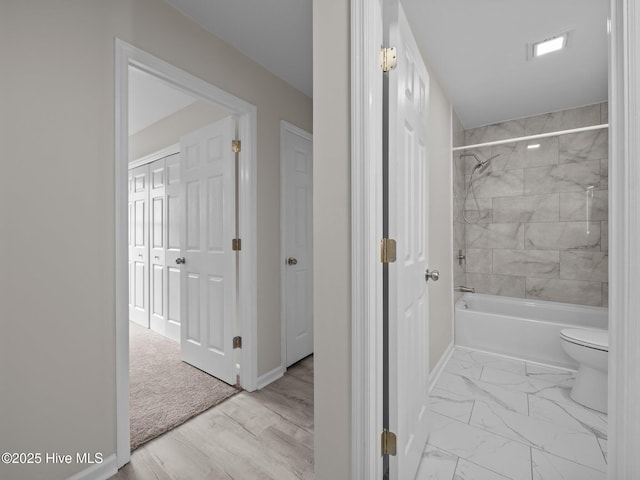 full bathroom with shower / bathtub combination, marble finish floor, toilet, and baseboards