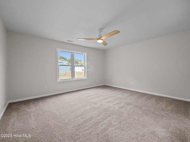 empty room featuring ceiling fan, carpet floors, and baseboards