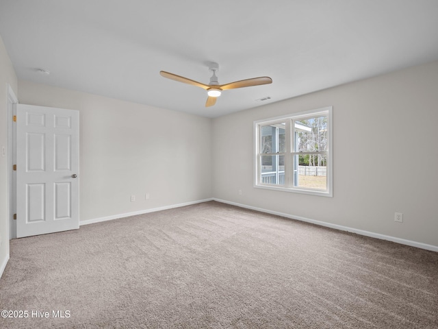 spare room with carpet floors, visible vents, and baseboards